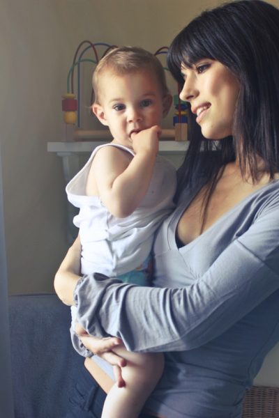 woman carrying baby boy wearing white tank top infront of 755028