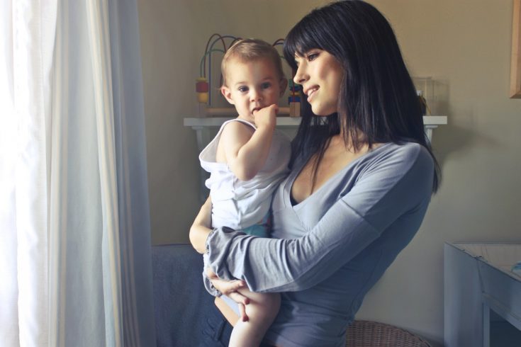 woman carrying baby boy wearing white tank top infront of 755028